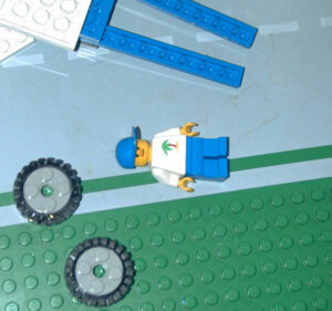 Photograph of the mini fig laying on the road