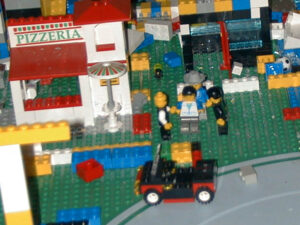 Photograph of the Lego mini fig being arrested by police at the Pizzeria